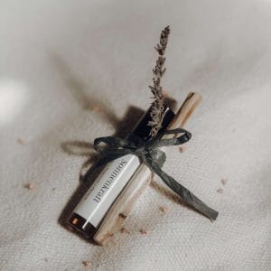 Ein Aroma Roll-On „Sonnenkraft“ zusammen mit einem Palo Santo Holzstab und einem Lavendelzweig, als Geschenkset von youyoga Rostock.