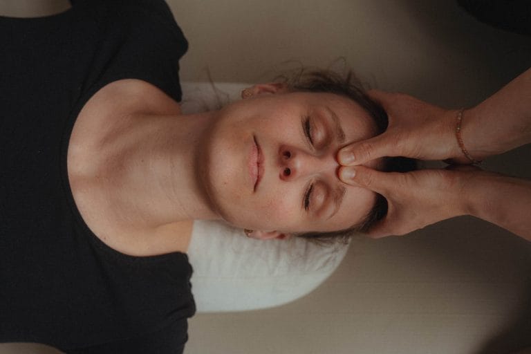 Mentale Entspannung und Achtsamkeit bei youyoga Rostock: Sanfte Berührung (Adjustment) an der Stirn während einer privaten Yogastunde zur Stressbewältigung.