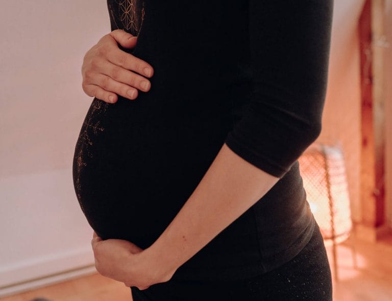 Achtsames Schwangerenyoga in Rostock: Yogalehrerin gibt sanfte Hilfestellungen bei einer entspannenden Haltung mit Yoga-Bolster zur Geburtsvorbereitung.